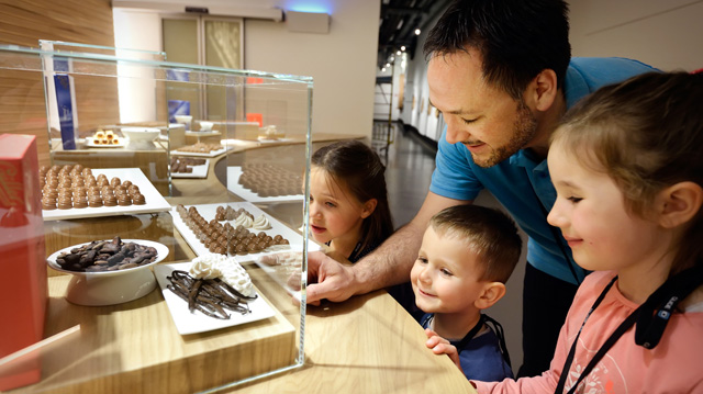 Family on chocolate tour in Switzerland looking at chocolates